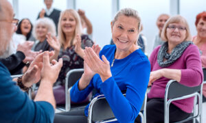 Image shows group of AMD patients applauding.