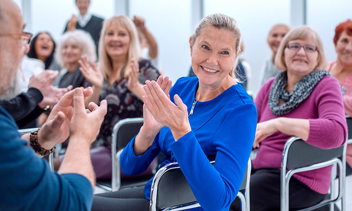 Image shows group of AMD patients applauding.