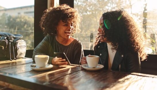 Two Image shows two vaccinated women enjoying coffee together, post pandemic restrictions.