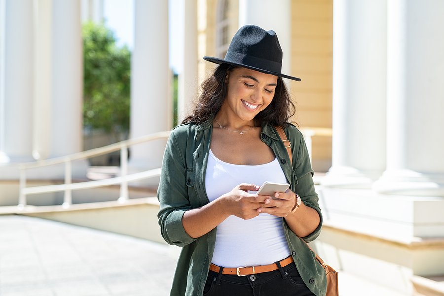 Smiling woman listens as smartphone reads to her.