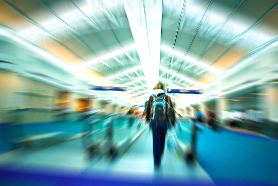 Travelers rushing through a busy airport terminal