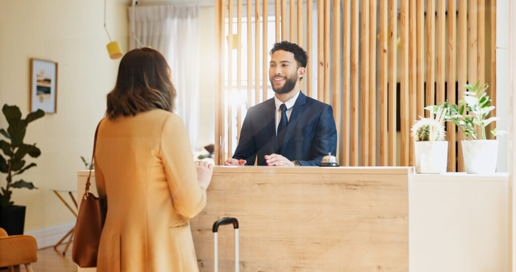 Hotel guest is warmly welcomed at reception desk for check-in