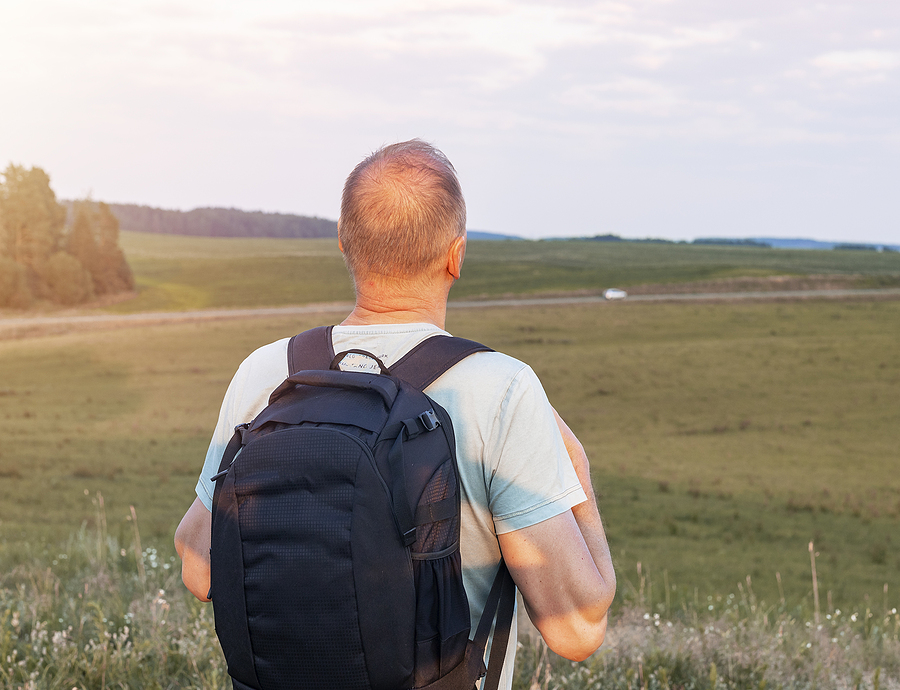 Image of man leaving home with go bag backpack following emergency evacuation.