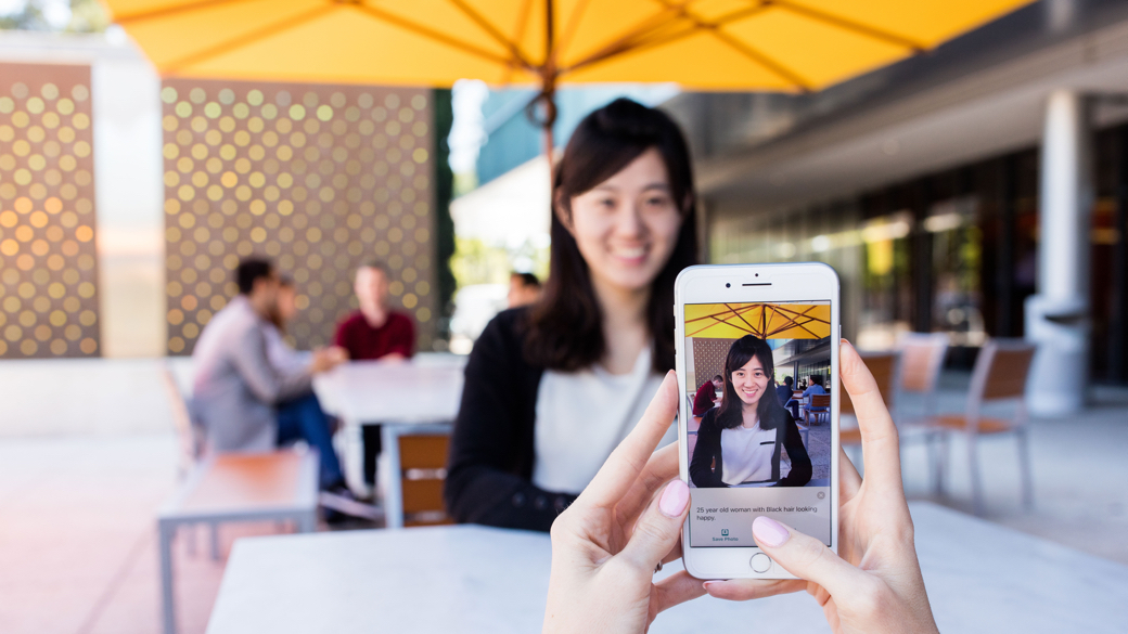 Microsoft Seeing AI app describing a person sitting outside. 