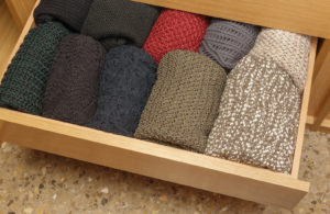 An organized drawer with folded clothing.