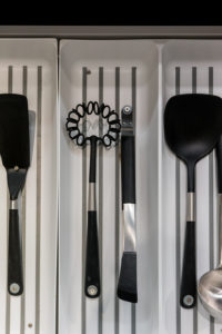 Cooking utensils neatly placed in a drawer kitchen organizer.