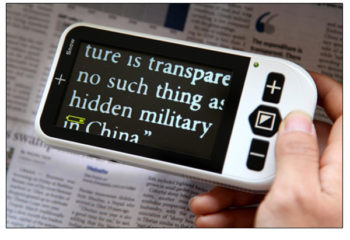 Portable video magnifier used on newspaper text.