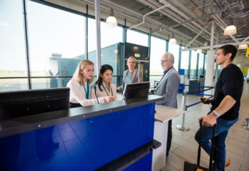 Airport terminal attendants checking in people.