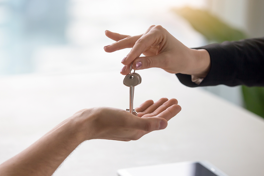 Close up of a hand taking a key from another hand.