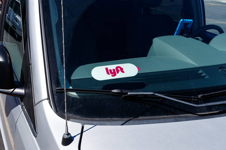 Silver car with a Lyft sticker on the windshield.