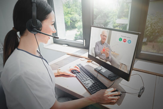 Image shows doctor consulting with patient on screen during video medical visit.