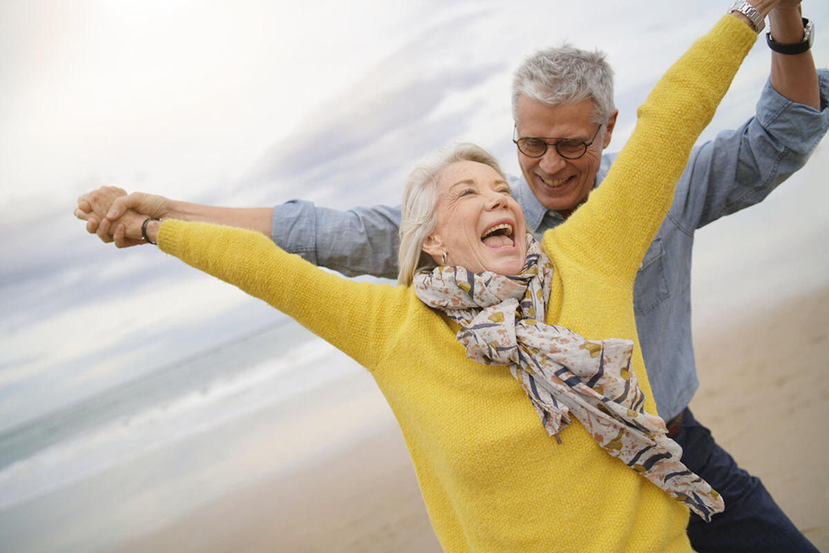 Image of woman dancing with man on beach.