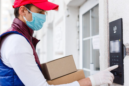 Image shows: Man with mask and gloves providing food delivery service to home.