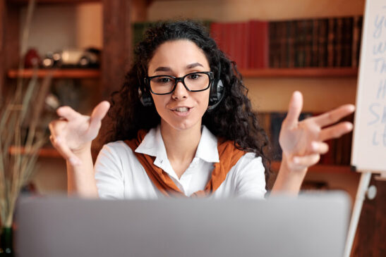 Image shows: Woman leads video business meeting from home.