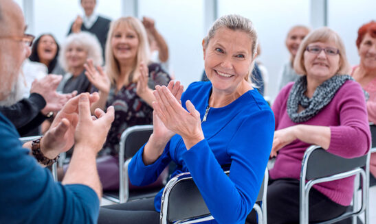 Image shows group of AMD patients applauding.