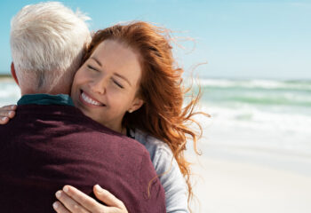 Image shows woman giving warm hug to loved one.