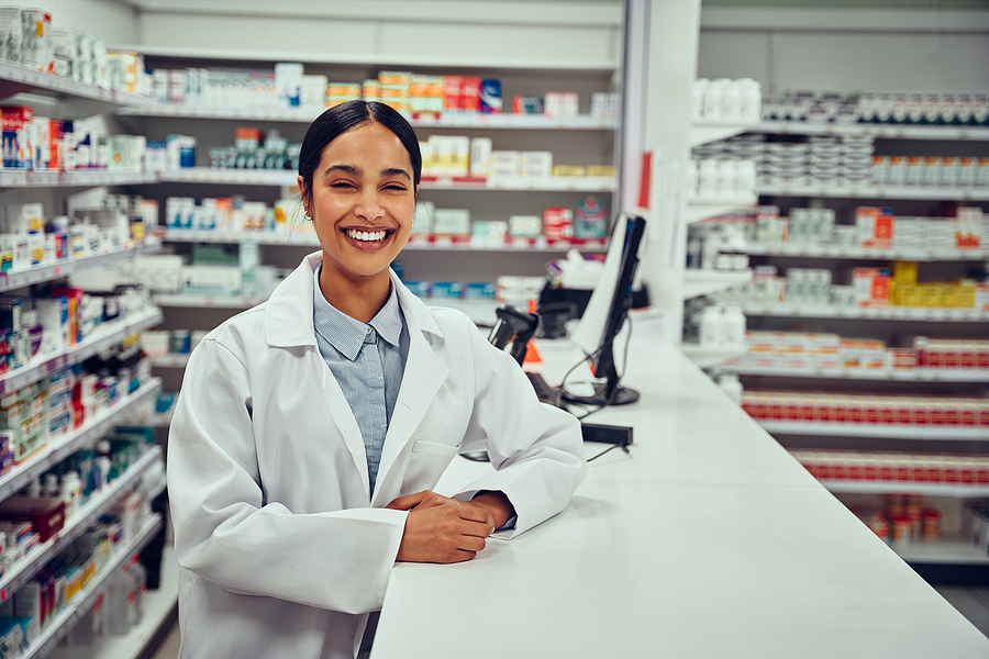 Image shows helpful, smiling pharmacist at work.