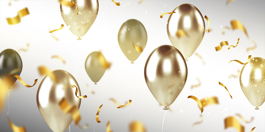 Celebratory golden balloons and confetti.