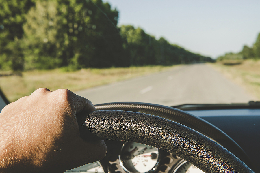 View of road from driver’s seat of car.