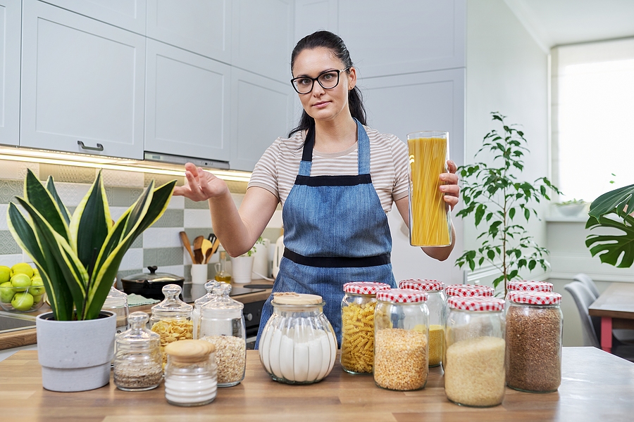 Woman wearing apron in prepped kitchen.