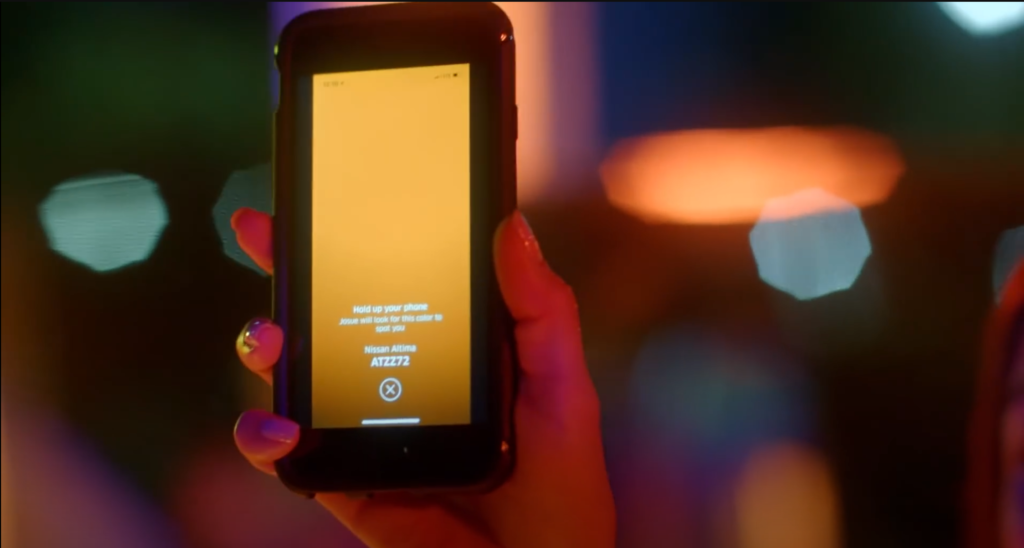 Hand holding up smartphone to display yellow screen for Uber Spotlight. Image credit: Uber