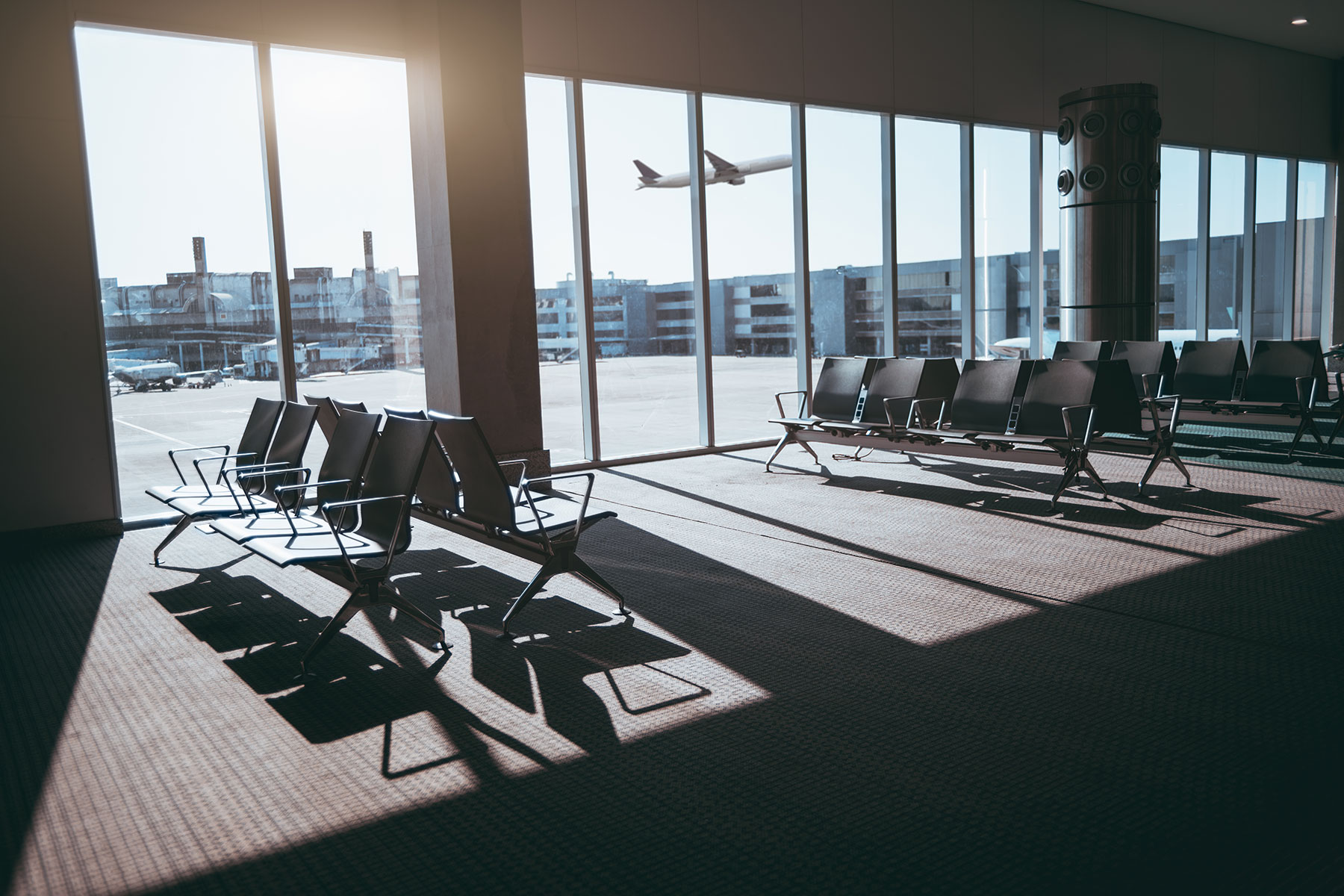 Airport waiting area windows looking out to departing plane