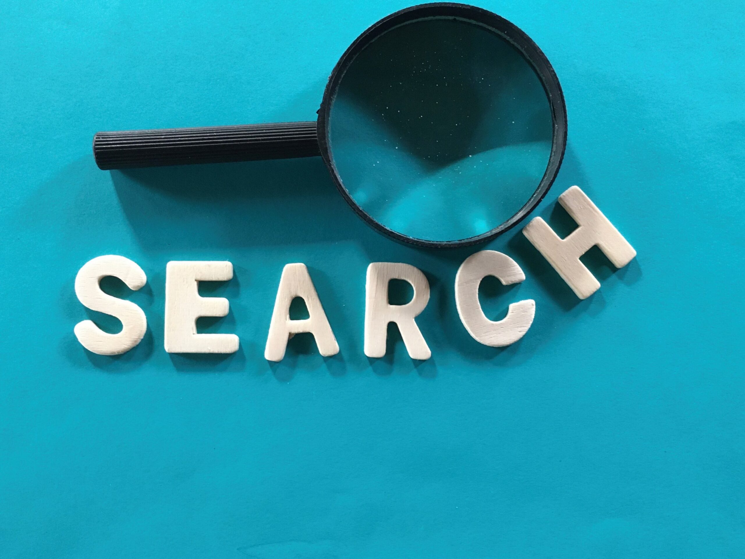 Magnifying glass with the word search on blue background