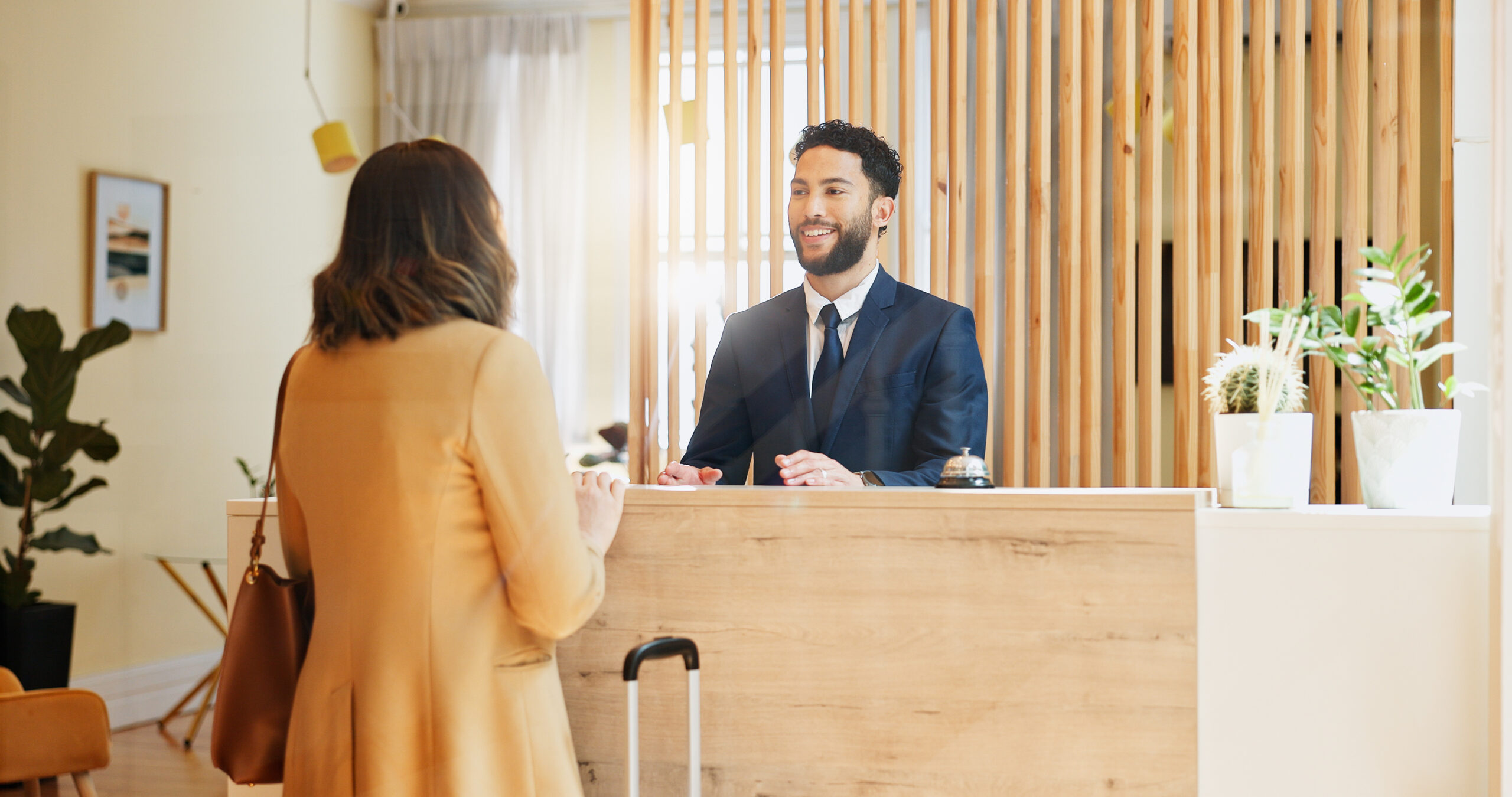 Hotel guest is warmly welcomed at reception desk for check-in